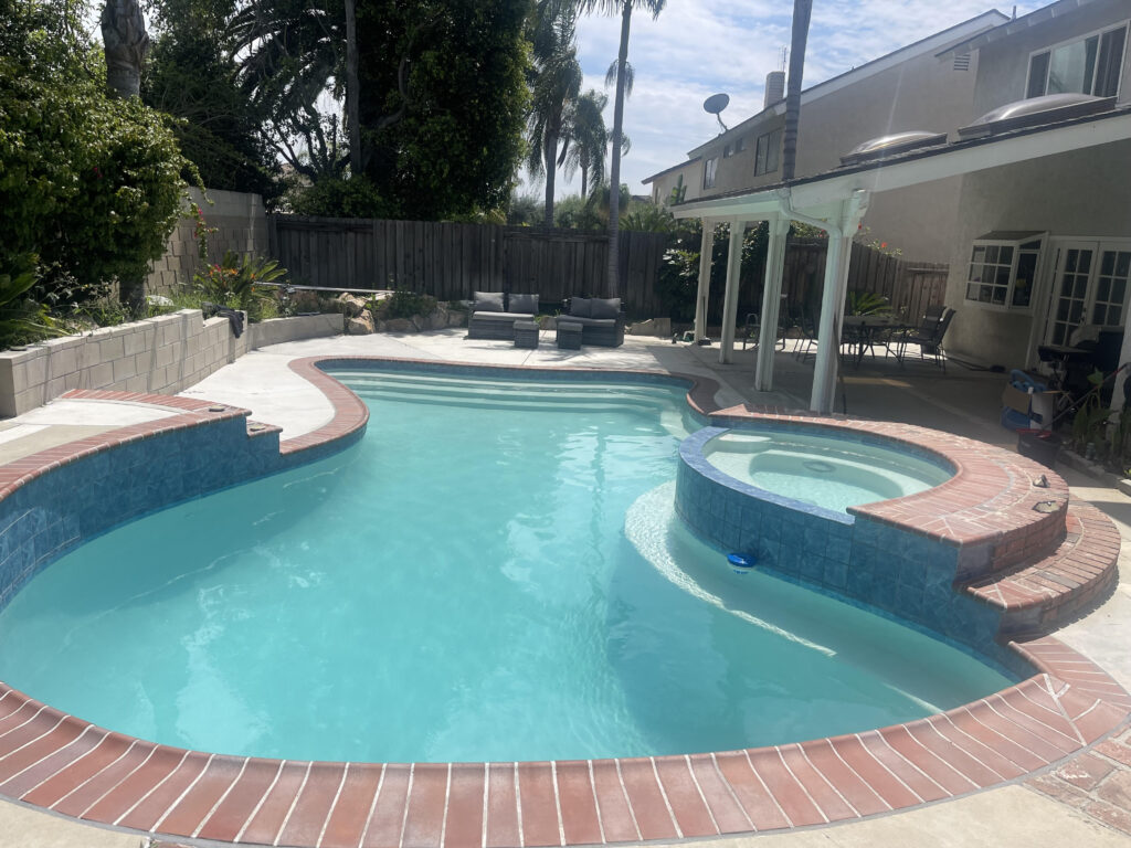 Pool from the side view. At one end you see the patio furniture and the backside of the house